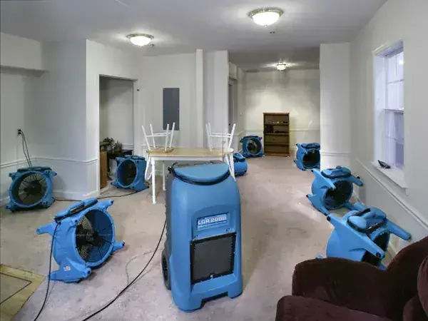 Air movers and a dehumidifier drying a room after a water loss